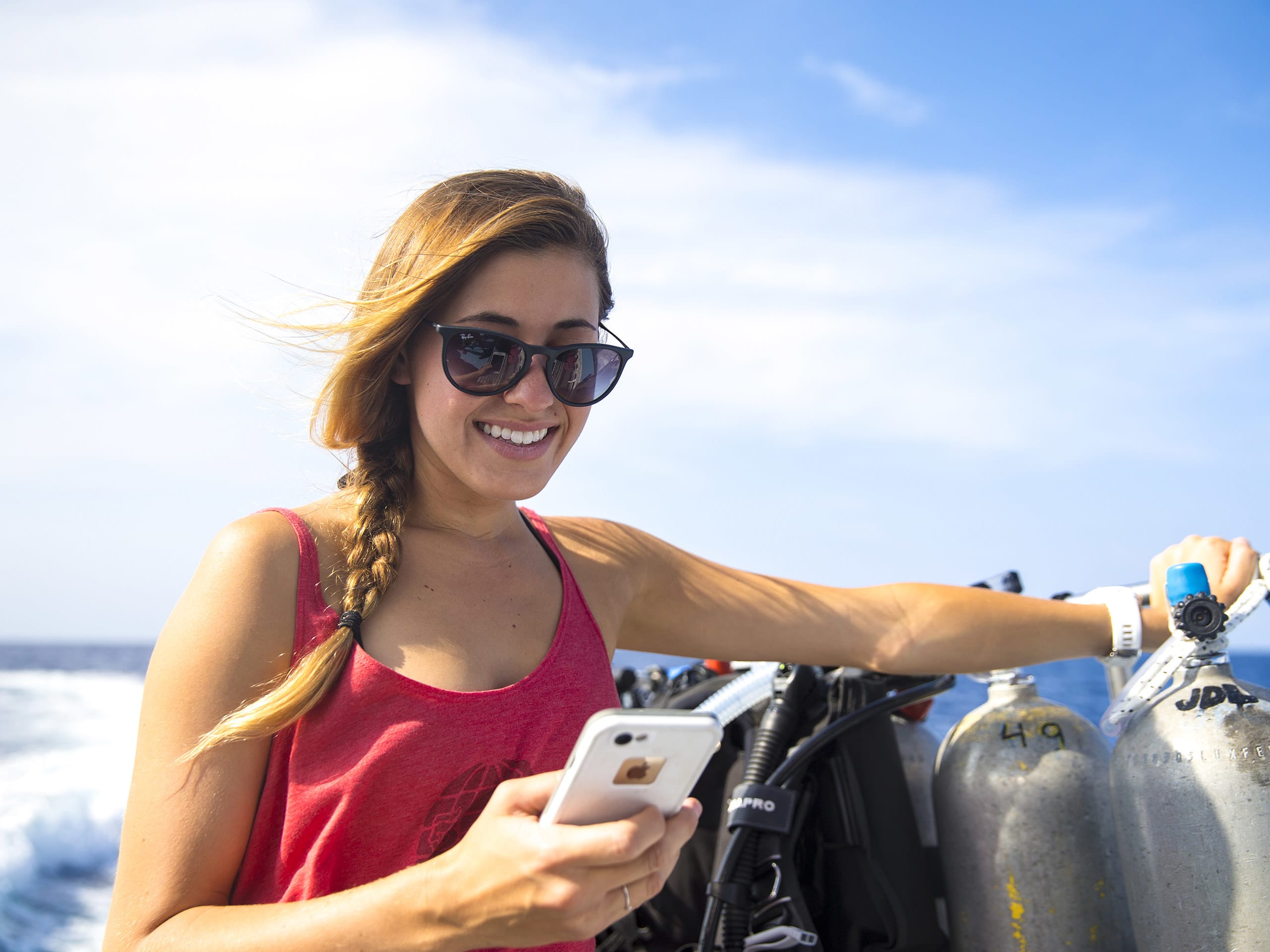 Woman on phone next to scuba tanks