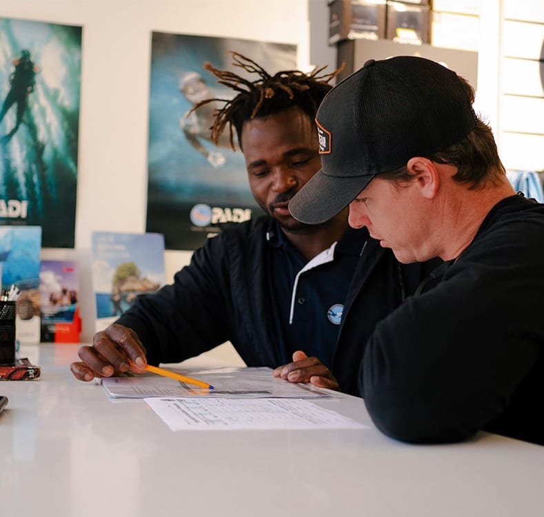 Student and instructor sitting at a desk reviewing.